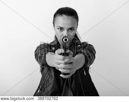 Close Up Of Young Asian Woman Aiming Handgun At Camera With Both Hands Against White Background