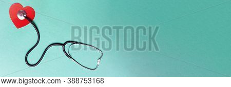Stethoscope And Red Heart On Green Background. Top View. Banner. Copy Space. Place For Text
