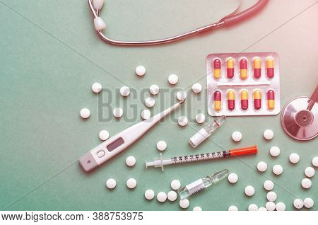 Pills, Ampoule, Syringes, Capsules, Stethoscope On The Green Doctor S Table.
