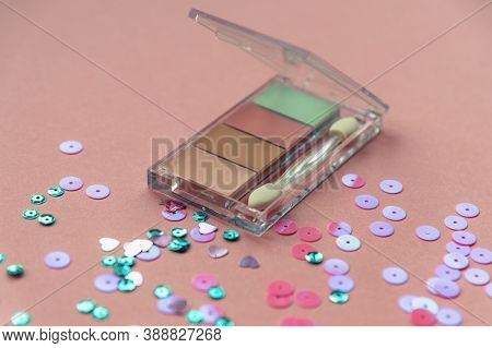 Colorful Eyeshadow On Coral Pink Background With Sparkles. Beauty Makeup Concept. Close Up