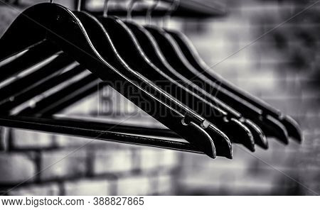 Wooden Coat Hanger Clothes. Wood Hangers Coat. Many Wooden Black Hangers On A Rod. Store Concept, Sa