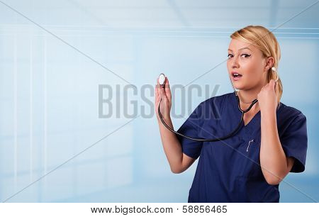 Pretty young nurse in hospital listening to empty copy space with sthetoscope