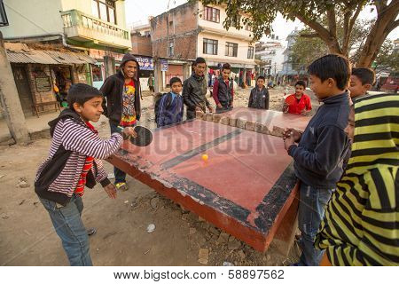 KATHMANDU, NEPAL - DEC 20: Unidentified teenagers from poor families play in table tennis in the slums, Dec 20, 2013 in Kathmandu, Nepal. Caste of untouchables in Nepal, is about 7 % of population.