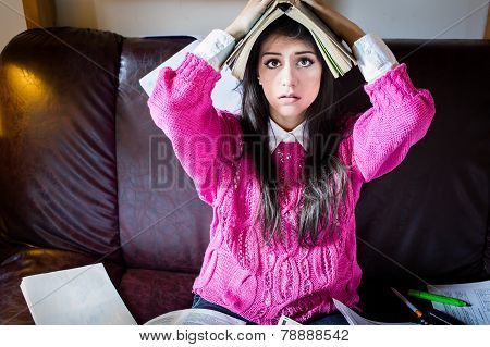 Funny looking brunette woman student trying to study in her room. Funny process of studying for exam