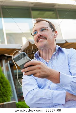 Middle age businessman using smartfone outdoors