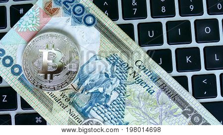 Bitcoin on Nigerian Naira banknote. Electronic money exchange concept