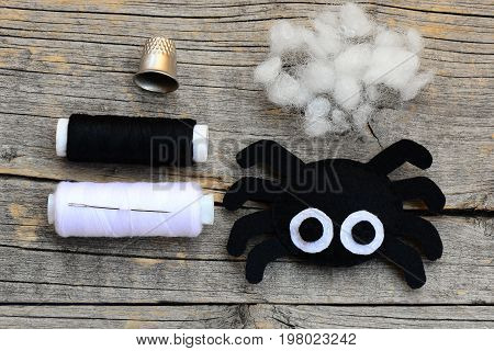 Making a Halloween felt spider decoration. Step. Cute spider ornament for Halloween decor. Craft set on a wooden table. Easy Halloween crafts and activities for kids. Top view. Closeup