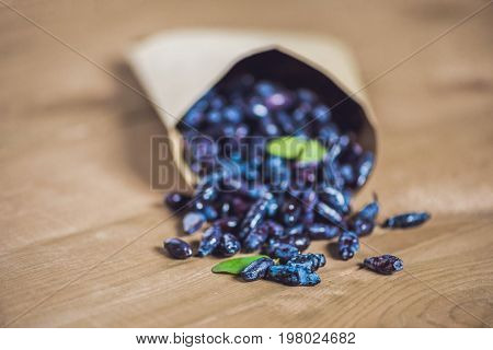 Fresh Honeysuckle Blue Berry Fruits With Leaf On A Wooden Background