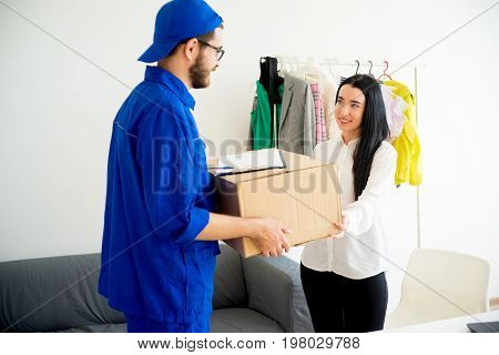 Woman accepting a box package from deliveryman