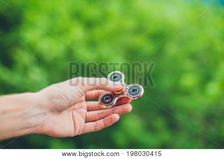 Close Up Of A Man's Hand Who Is Holding A Fidget Spinner In A Park
