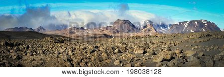 Dramatic volcanic rock desert and mountains of Porisjokull with stormy clouds in sunset light. Icelandic highland near Kaldidalur.