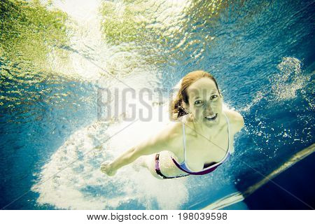 a young woman is jumping into the water from a diving plattform