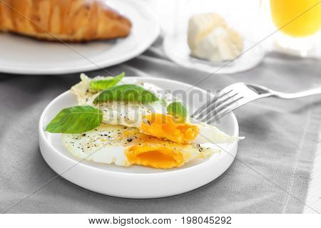 Plate with delicious over hard fried eggs on tablecloth