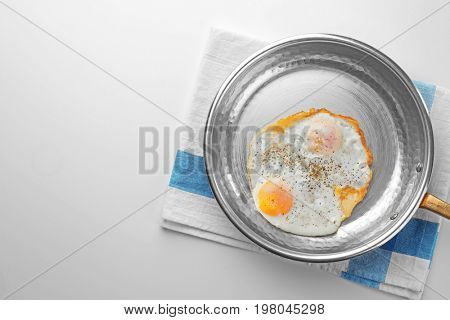Pan with over hard fried eggs on light table