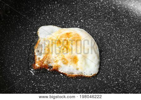 Frying pan with over hard fried egg, closeup
