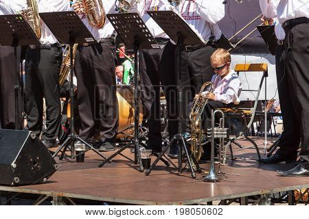 Buchlovice Czech Republic July 29 2017: Little boy plays trumpet at folk festivities. Gifted child. Traditional farmers harvest celebrations of garlic