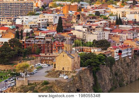Sunset aerial view on Metekhi Church of the Dormition of the virgin.Monument to Vakhtang I Gorgasali. Famous landmarks in Tbilisi Georgia.