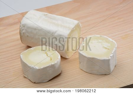 Goat cheese on wood background, brown color