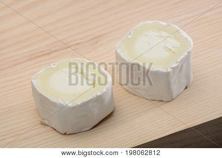 Goat cheese on wood background, brown color