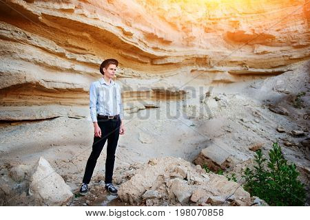 An Attractive Man Is Standing In The Middle Of A Sand Quarry And Looking Thoughtfully In The Distanc