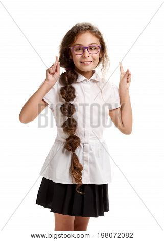 Young smiling genious schoolgirl in glasses pointing up