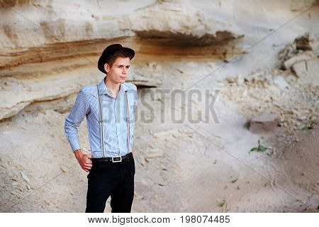 Stylish Attractive Man Stands In The Middle Of A Sand Quarry And Poses On The Camera