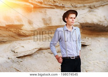 Stylish Attractive Man Stands In The Middle Of A Sand Quarry And Poses On The Camera
