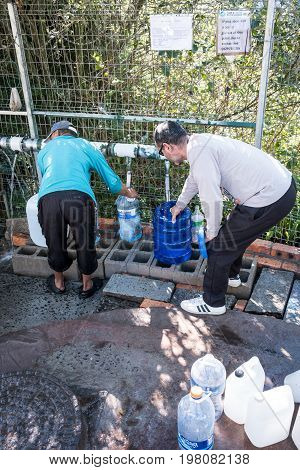 Cape Town South Africa - circa July 2017. As the devestating drought continues in the Western Cape Province of South Africa people in Cape Town are left with no choice other than to fill up water bottles and containers at the many mountain springs running