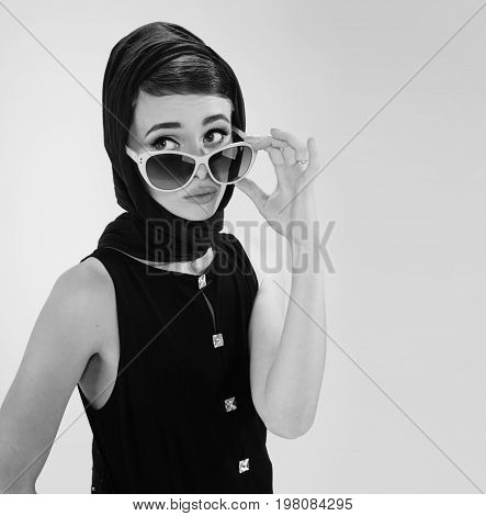 beautiful young woman in retro style with sunglasses and a head scarf black and white photography