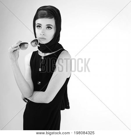beautiful young woman in retro style with sunglasses and a head scarf black and white photography