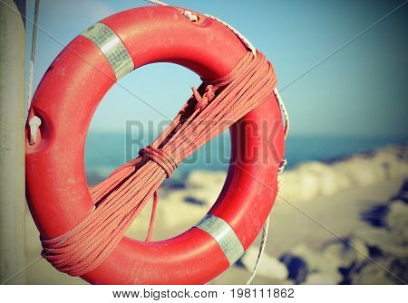 Orange Lifebuoy For People Near The Rocks