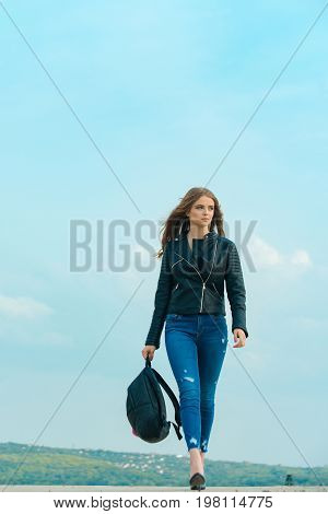 Girl in leather jacket. Beauty and fashion. Fashion model on blue sky. Sexy woman outdoor. Woman with long hair with backpack