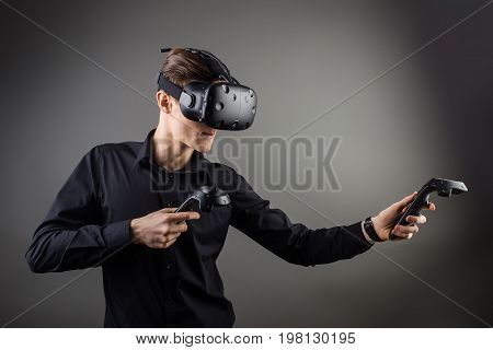 Attractive Man Wearing Virtual Reality Headset With Two Handheld Trackpads Or Controllers