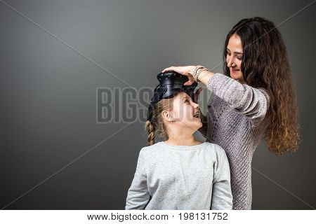 Mother And Child Playing Together With Virtual Reality Headsets Indoors At Home