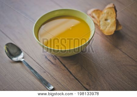 Pumpkin and carrot soup with cream and parsley