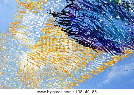 Abstract colorful background made from lot of diversity cloth against blue sky