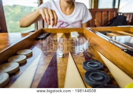 playing backgammon game on a beautiful wooden table with dices and tokens
