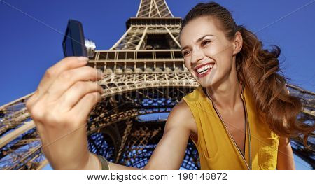 Woman Taking Selfie With Digital Camera Against Eiffel Tower