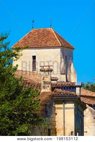 Roof of a French traditional house with a weathercock and a lightning rod on a beautiful blue sky