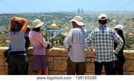 Jerusalem, Israel - May 25, 2017: The guide shows the Jerusalem Old City view to the tourists and pilgrims. Mount of Olives is a famous Holy Land place and it has a fantastic view to the Old Jerusalem