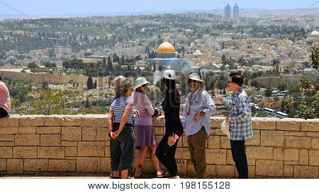 Jerusalem, Israel - May 25, 2017: The guide shows the Jerusalem Old City view to the tourists and pilgrims. Mount of Olives is a famous Holy Land place and it has a fantastic view to the Old Jerusalem