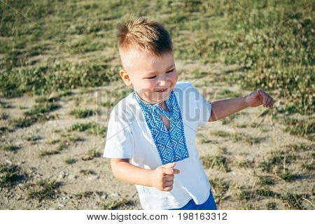 little boy playing on the top of the mountain with beautifull view on background