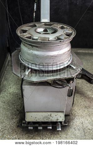 Rim with no tyre over mounting machine. Installing wheel process