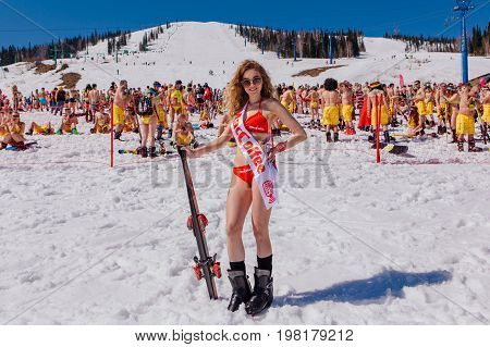 Sheregesh, Kemerovo region, Russia - April 22, 2017: Grelka Fest is a sports and entertainment activity for ski and snowboard riders in bikini in Russia, Sheregesh. Young happy pretty women with mountain ski in red bikini.