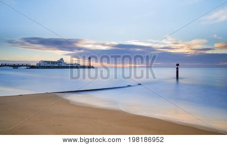 The sun rises over the sea at Bournemouth illuminating the cloads and the sea