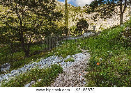 Ancient Serbian church ruins and mountain valley landscape near Kotor castle in Montenegro. Old mountain church and monastery in Kotor Bay region near hike path to Lovchen mountain. Saint Ivan chapel.