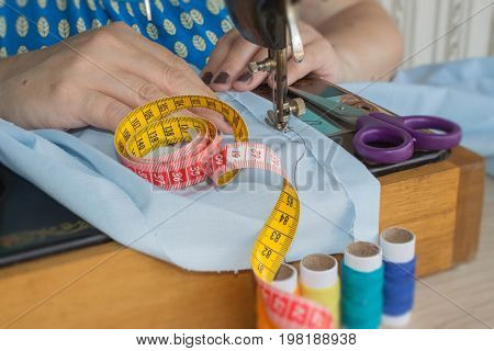 Sewing Process the sewing machine sew women's hands sewing machine. sewing machine and female scissors