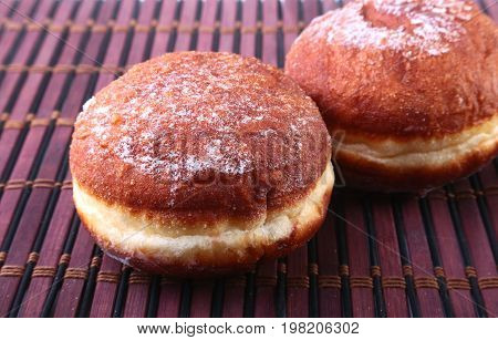 Homemade Doughnuts with Jelly filled and powdered sugar on Bamboo tablecloth. Selective focus