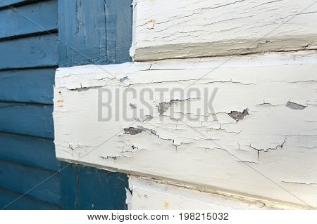 White paint flaking from boards on old building