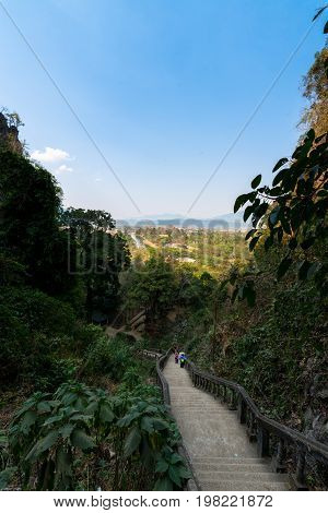 VANG VIENG LAOS - MARCH 14 2017: Vertical picture of the stairs to reach the Tham Chang Cave in the city of Vang Vieng Laos. Tropical Vegetation.